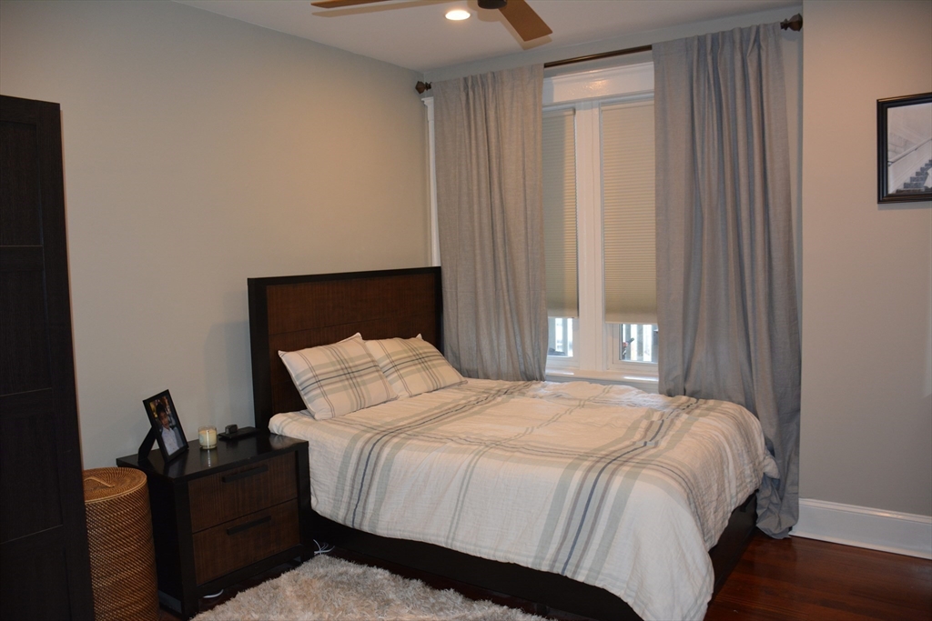54 Dwight Street, Unit 3 Brookline, MA 02446 - Photo 10 of 16 a bedroom with a bed and wooden floor
