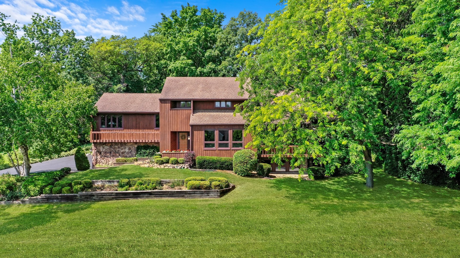 a view of a house with a big yard and large trees