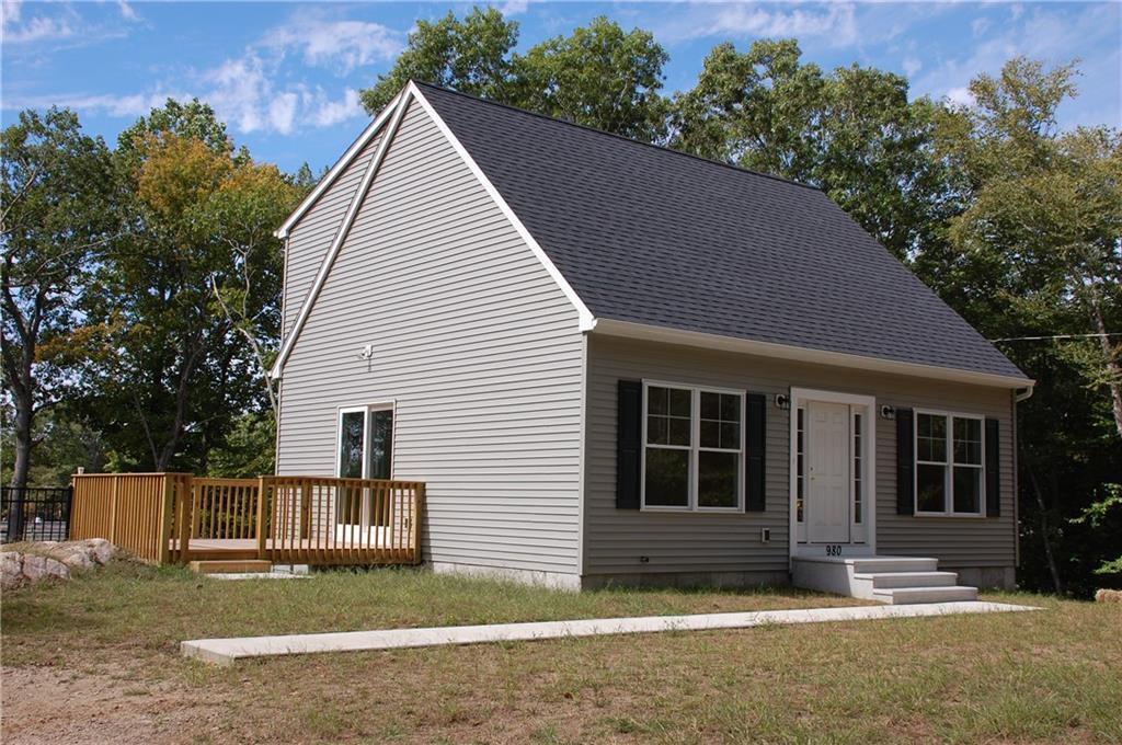 a view of a house with a yard and large tree