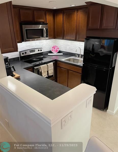 182 Ventnor L, Unit 182 Deerfield Beach, FL 33442 - Photo 14 of 28 a kitchen with a cabinets and appliances