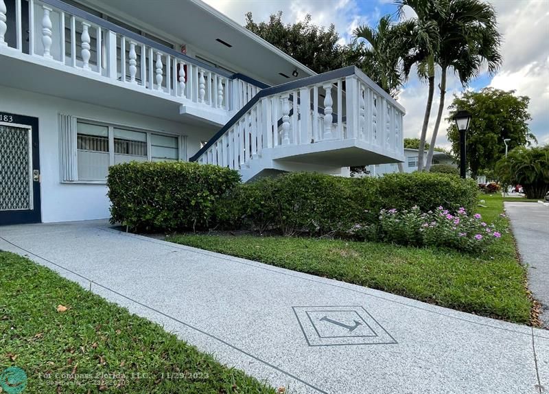 182 Ventnor L, Unit 182 Deerfield Beach, FL 33442 - Photo 2 of 28 a front view of a house with a garden