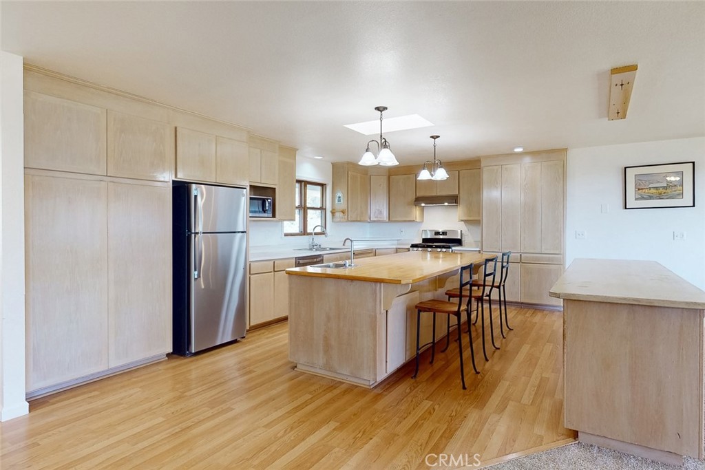 1718 Robinson Mill Road Bangor, CA 95914 - Photo 12 of 74 a kitchen with stainless steel appliances granite countertop a refrigerator a stove a sink dishwasher and a dining table with wooden floor