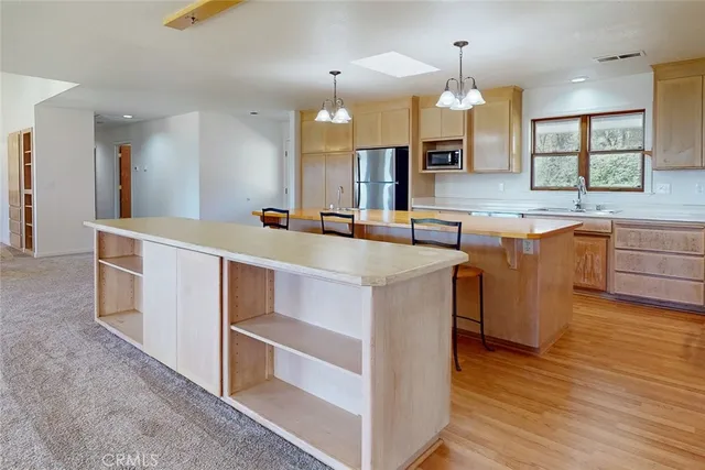 a large kitchen with stainless steel appliances granite countertop a sink and cabinets