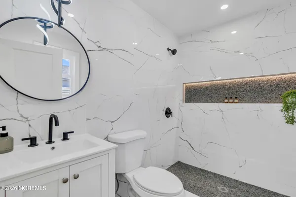 a bathroom with a sink a toilet and a mirror