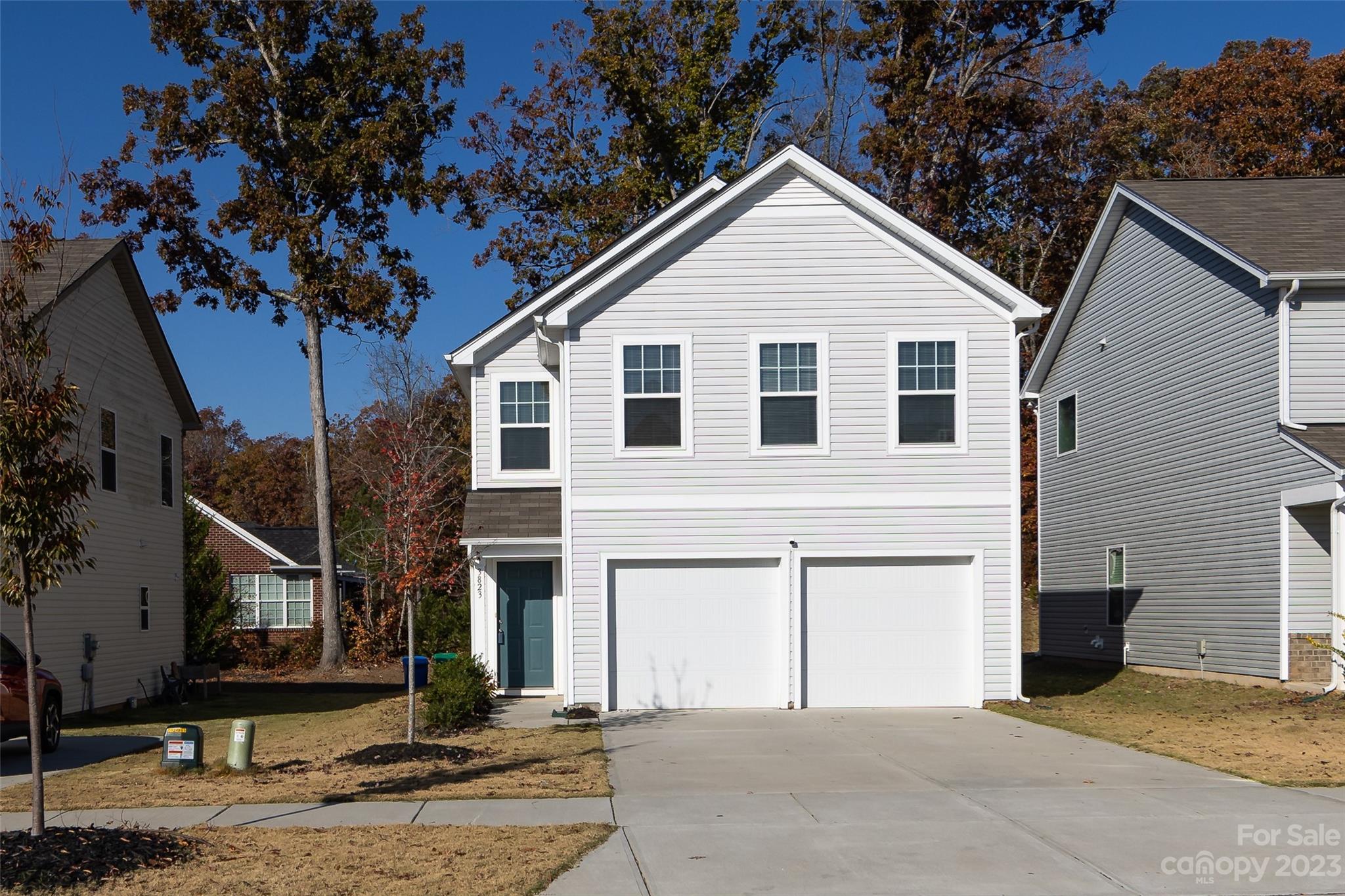 a view of a white house with a large tree