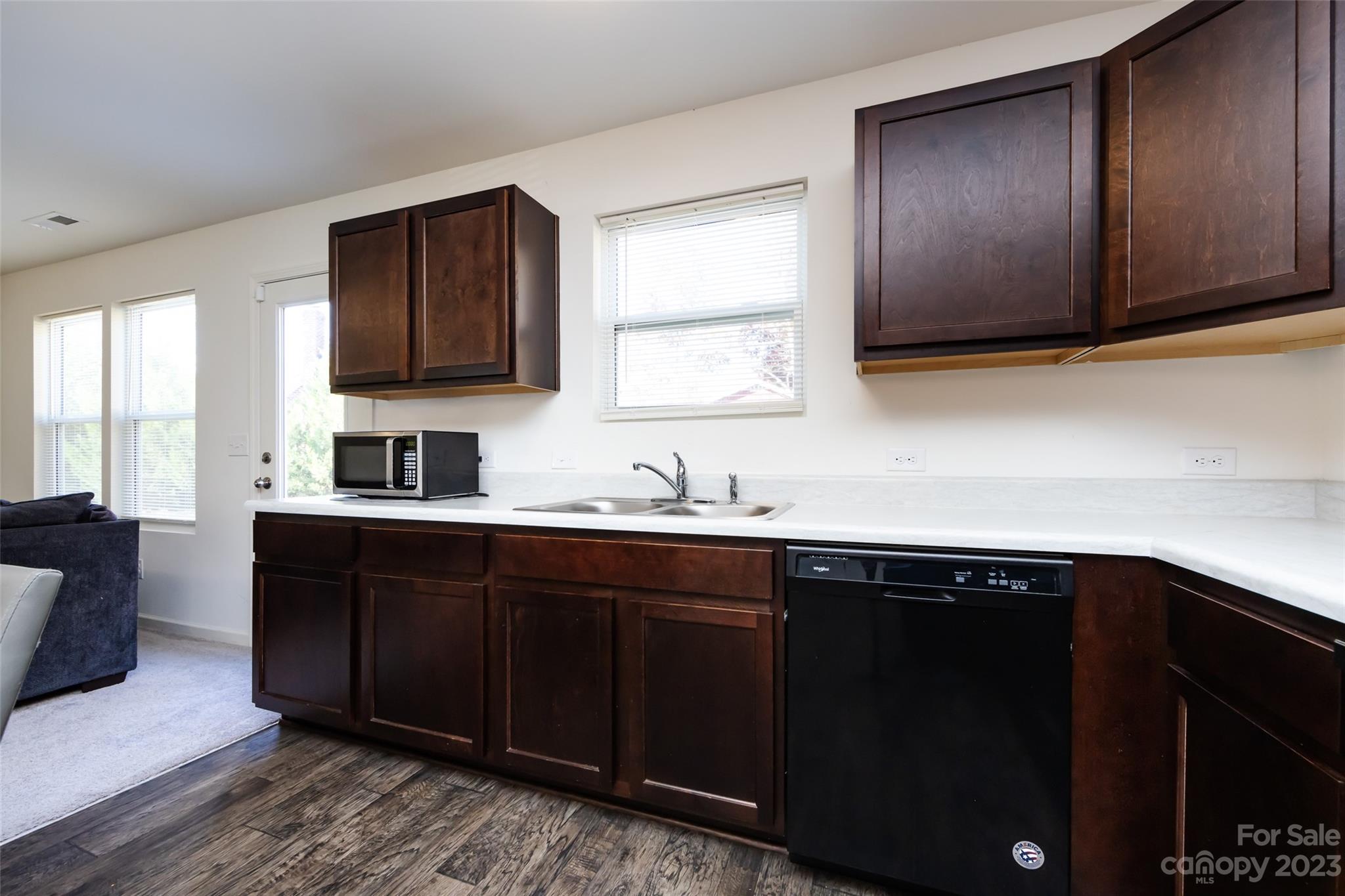 3823 Tersk Drive Midland, NC 28107 - Photo 10 of 24 a kitchen with stainless steel appliances granite countertop a sink dishwasher a stove and black cabinets with wooden floor