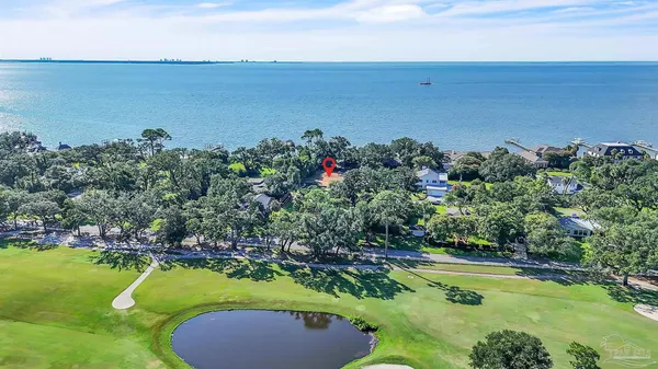 an aerial view of a house with a yard and lake view
