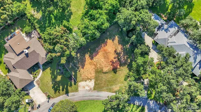 an aerial view of residential house with outdoor space and trees all around
