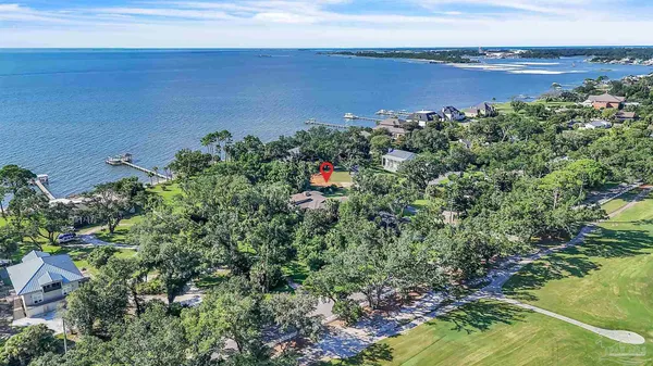 an aerial view of a house with a yard and lake view