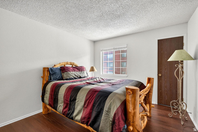 407 South Vasels Road, Unit 24 Brian Head, UT 84719 - Photo 17 of 63 Bedroom featuring wood-type flooring, a textured ceiling, and a textured wall