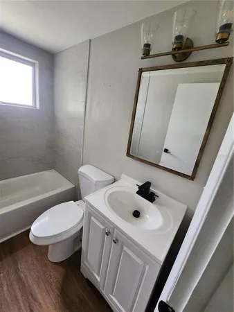 a bathroom with a toilet sink and mirror