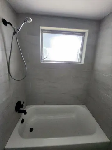 a bathroom with a tub and a window