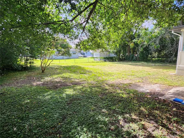 a view of yard with swimming pool and trees