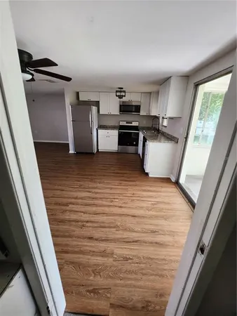 a view of kitchen with sink and refrigerator