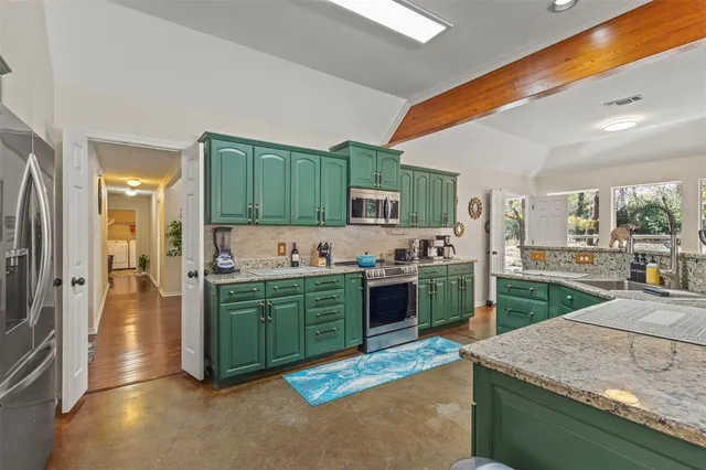 a kitchen with kitchen island granite countertop a sink stove and refrigerator