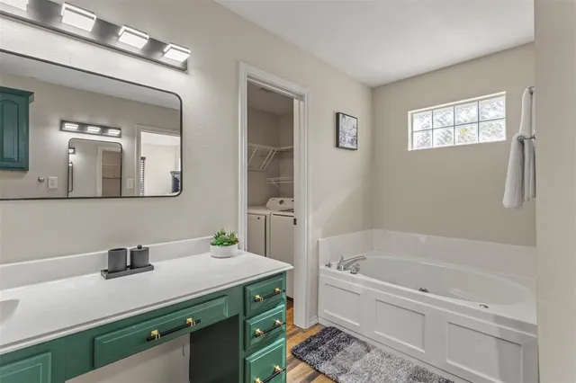 a bathroom with a bathtub a sink and a mirror