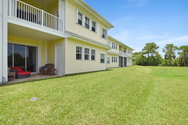a very nice looking house with a big yard and large trees