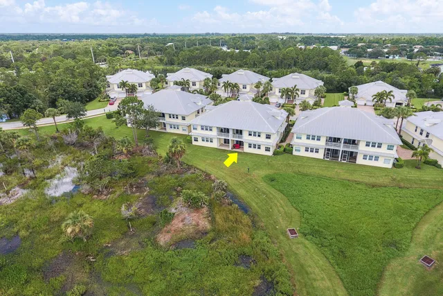 an aerial view of residential houses with outdoor space and trees