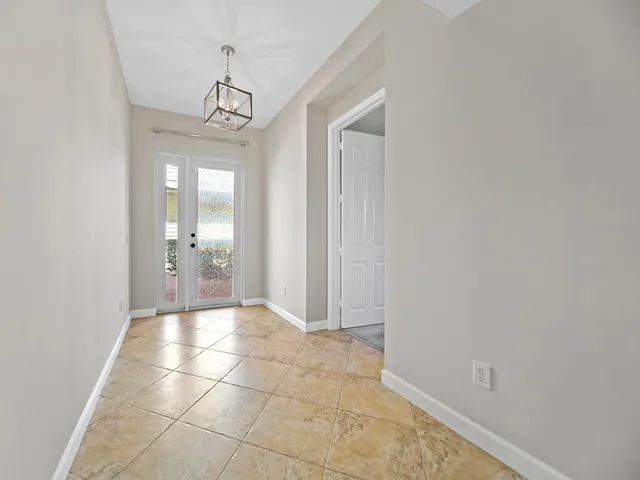 a view of a hallway with a chandelier and dining room view