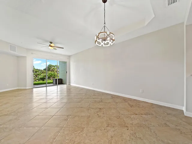 a view of a room with a chandelier potted plants and wooden floor