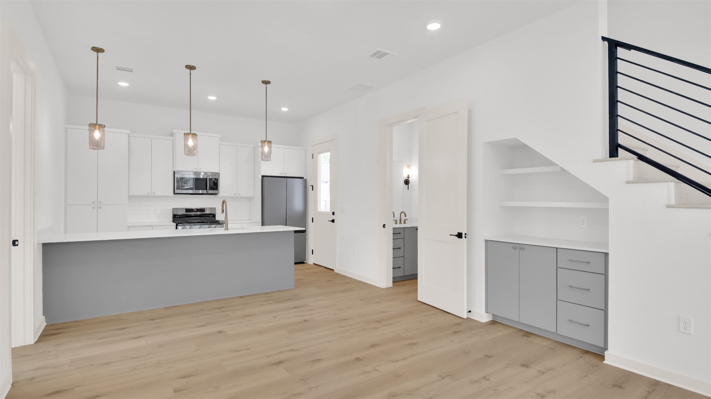 7208 Providence Avenue, Unit 1 Austin, TX 78752 - Photo 4 of 26 Open-concept living area featuring a modern kitchen with a large island, white cabinetry, and stainless steel appliances
