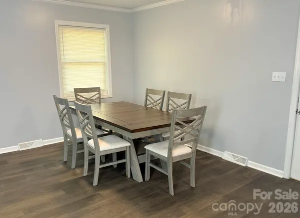 a dining room with furniture and wooden floor