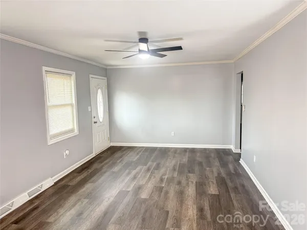 an empty room with windows and fan