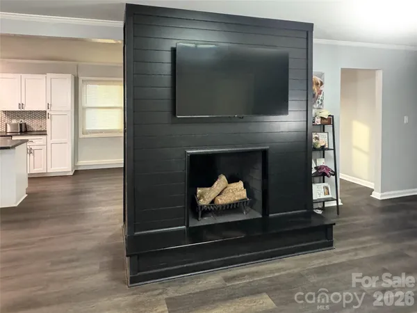 a living room with wooden floor and a fireplace