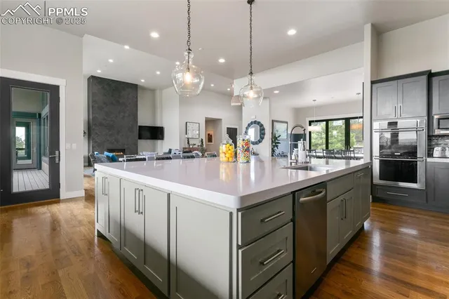 a kitchen with kitchen island granite countertop a sink appliances and cabinets