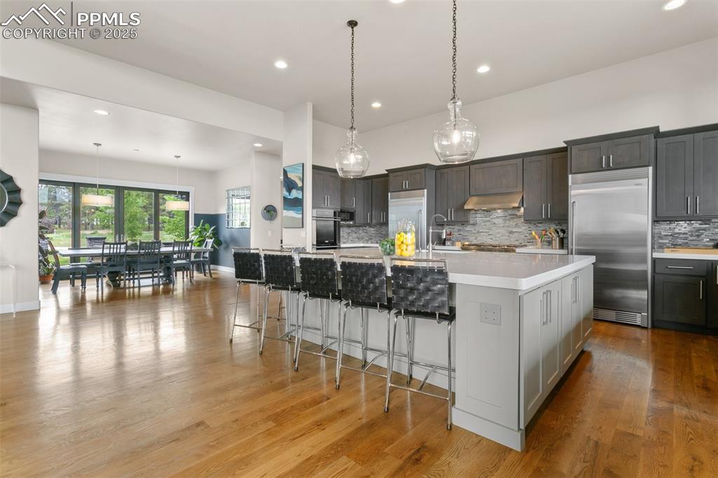 843 Long Timber Monument, CO 80132 - Photo 14 of 50 a kitchen with stainless steel appliances kitchen island granite countertop a large center island attached withe living room