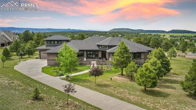 a front view of a house with a yard and mountain
