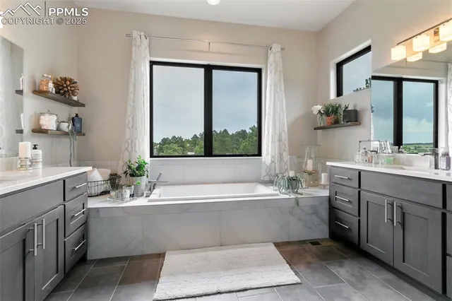 a bathroom with a bathtub a sink and a large mirror