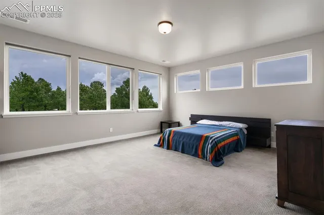 a spacious bedroom with a bed and wooden floor