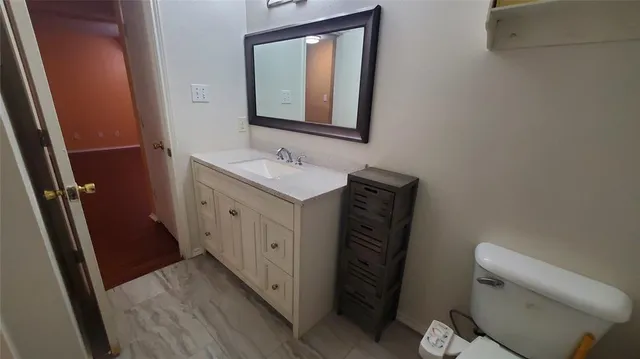 a bathroom with a toilet sink and mirror