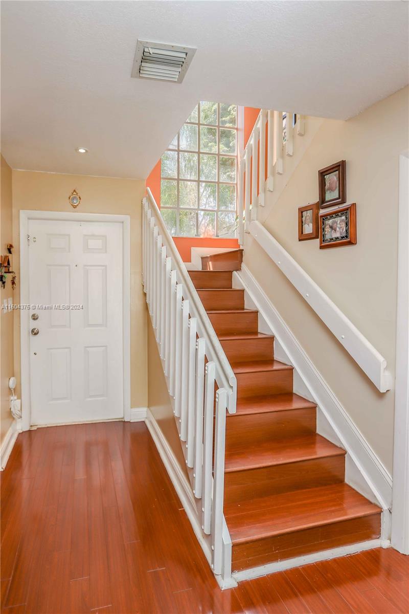 15253 Southwest 111th Street Miami, FL 33196 - Photo 11 of 32 a view of staircase with lots of frames on wall and wooden floor