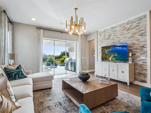 a living room with furniture a chandelier and a flat screen tv