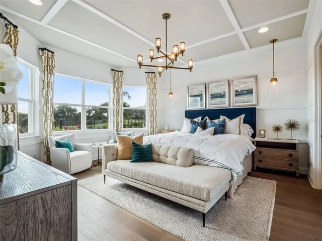 a bedroom with a large bed mirror and a large window