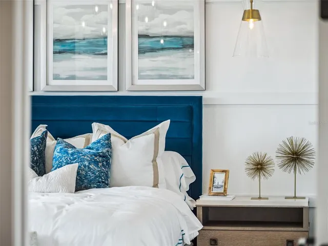 a bedroom with a bed a window and potted plant