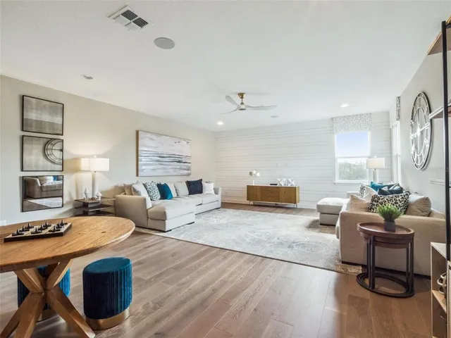 a living room with furniture a flat screen tv and a table