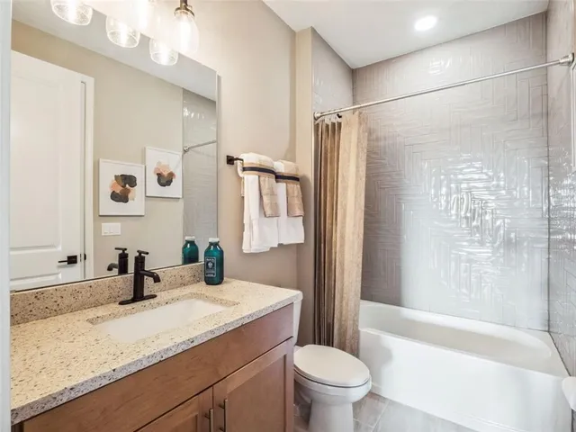 a bathroom with a granite countertop sink toilet and shower