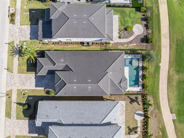 an aerial view of a house with swimming pool and mountains