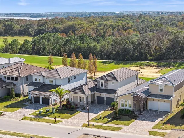 an aerial view of residential houses with outdoor space and swimming pool