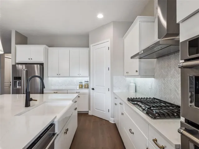 a kitchen with kitchen island a sink stove top oven and cabinets