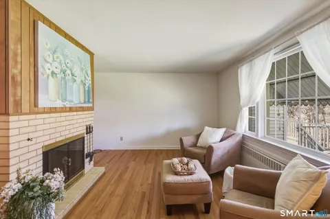 a view of a hallway with wooden floor and a living room