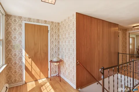 a view of a hallway with wooden floor and entryway
