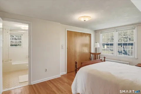 a bedroom with a bed a chair and a large window