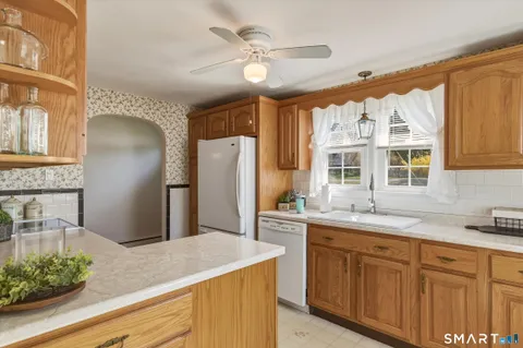 a kitchen with stainless steel appliances granite countertop a sink and a refrigerator