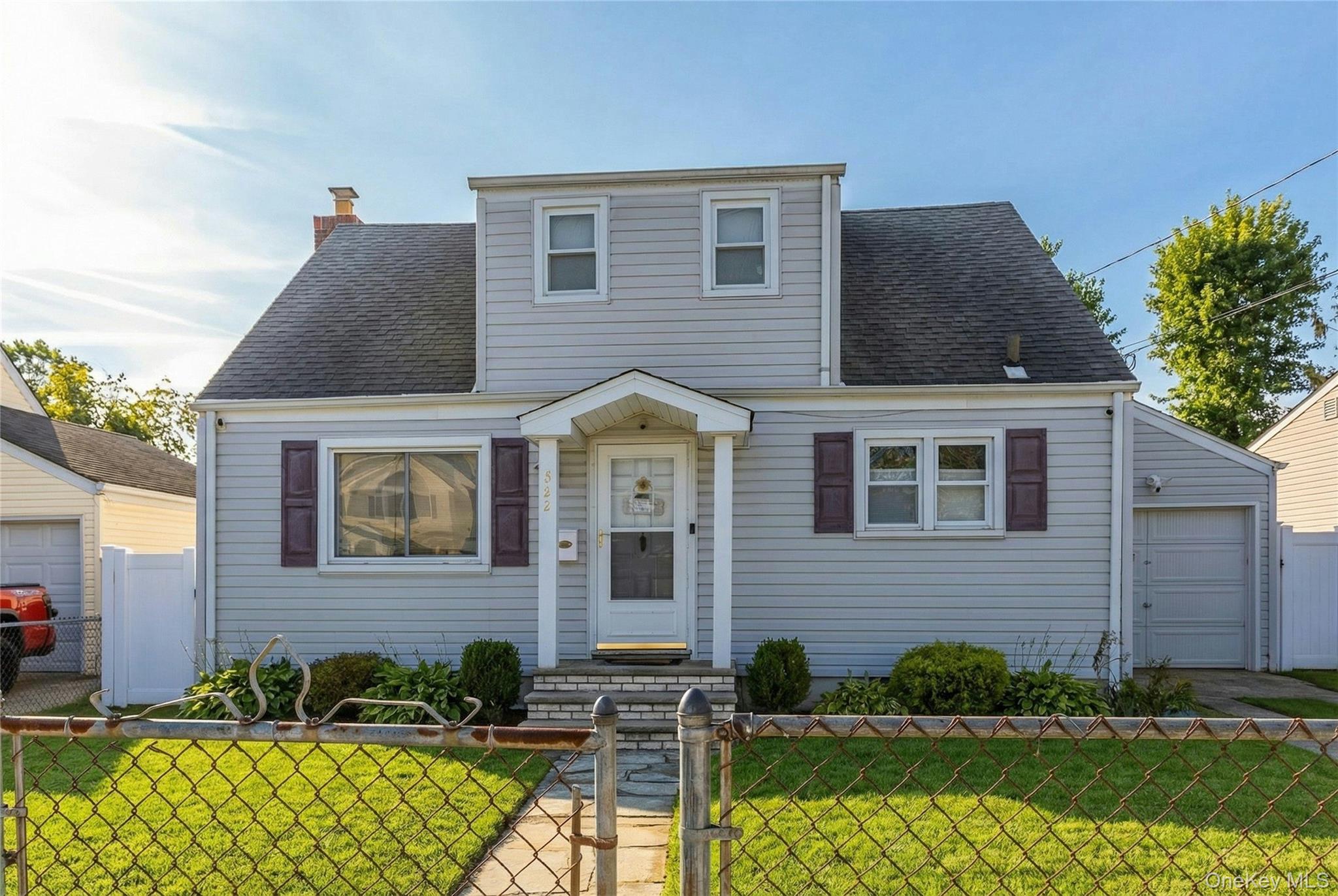 View of front of home featuring a gate, a fenced front yard, a shingled roof, and a chimney