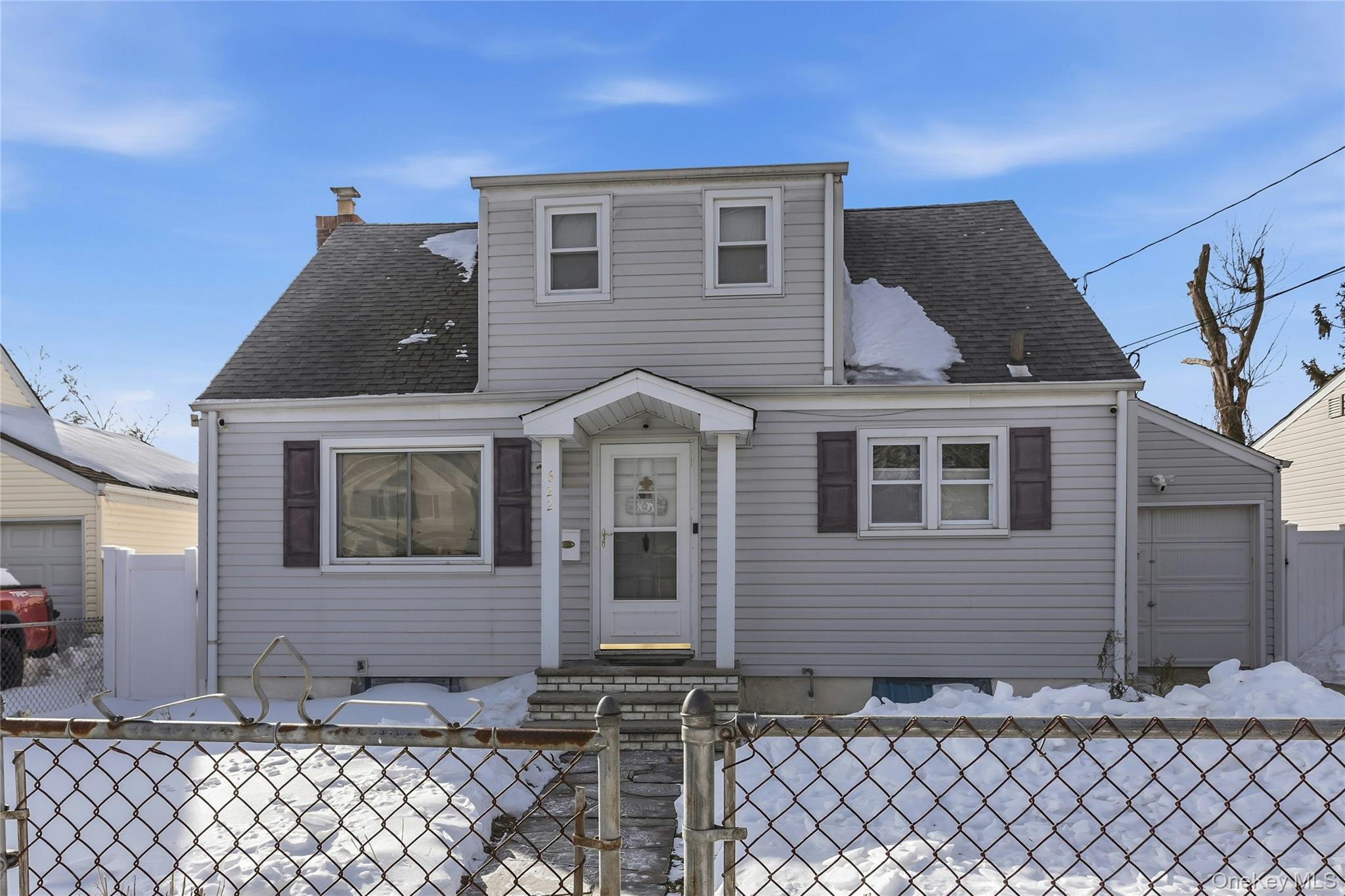 622 Wellelein Road Uniondale, NY 11553 - Photo 2 of 18 View of front of property featuring a gate, a fenced front yard, a shingled roof, and a chimney
