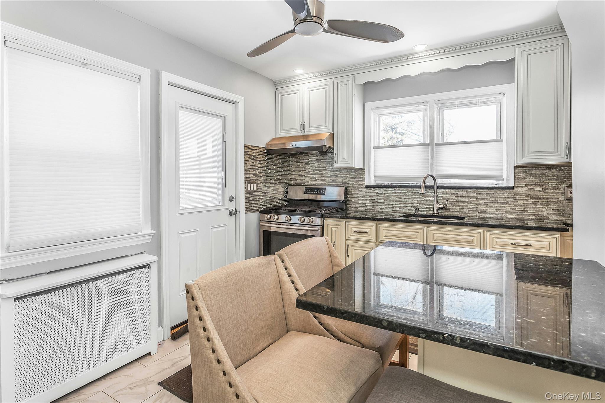 622 Wellelein Road Uniondale, NY 11553 - Photo 5 of 18 Kitchen featuring radiator heating unit, dark stone counters, gas stove, backsplash, and recessed lighting
